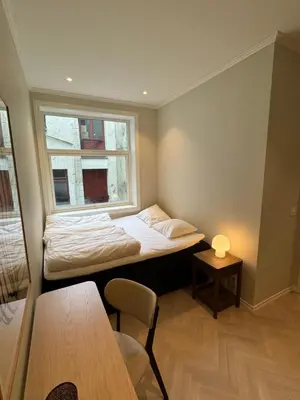 a small room with a bed and a window at MB25 Apartment in Bergen