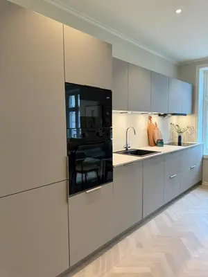 a kitchen with white cabinets and a sink at MB25 Apartment in Bergen
