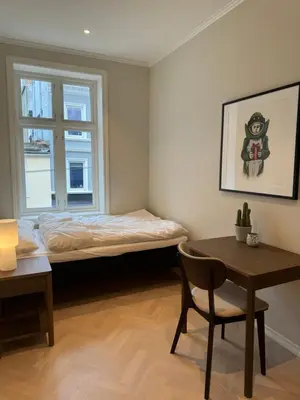 a bedroom with a bed and a table and a chair at MB25 Apartment in Bergen