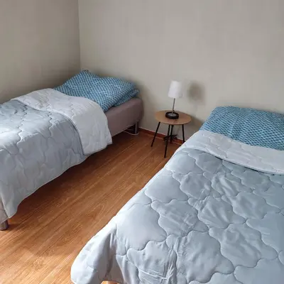 a bedroom with two beds and a table with a lamp at Leilighet nær E4 i sentrum av Eina in Eina