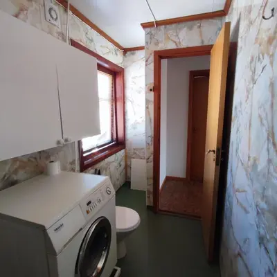 a bathroom with a washing machine and a toilet at Leilighet nær E4 i sentrum av Eina in Eina