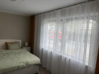 a bedroom with a bed and a window with white curtains at Magnhilds Luxury Apartment in Otta