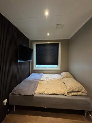 a small bedroom with a bed and a window at CozyStay Beside Historic Bryggen in Bergen