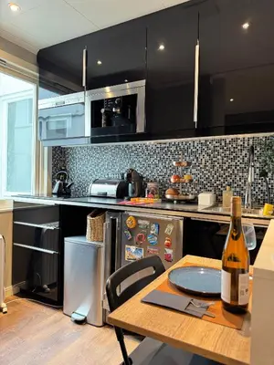 a kitchen with a table with a bottle of wine at CozyStay Beside Historic Bryggen in Bergen