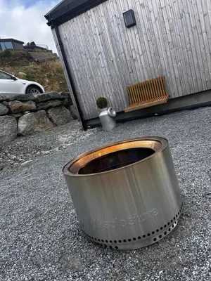 a metal barrel sitting on the ground in front of a building at Rinden cabin in Sogndal