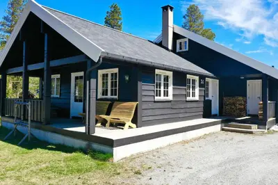 a blue house with a bench in front of it at Dream cabin by Geilo, ski-in ski-out with room for the whole family in Geilo