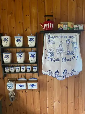 a display of pottery on a wooden wall with a banner at Trollslottet på Skeikampen in Aulstad