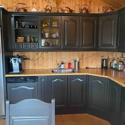 a kitchen with black cabinets and a sink at Trollslottet på Skeikampen in Aulstad