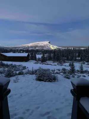 a snow covered field with a mountain in the background at Trollslottet på Skeikampen in Aulstad
