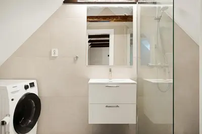 a bathroom with a sink and a washing machine at Bergen City Living in Bergen