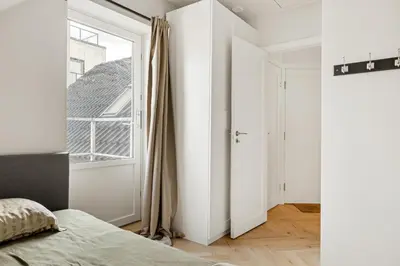 a bedroom with white walls and a window and a bed at Bergen City Living in Bergen