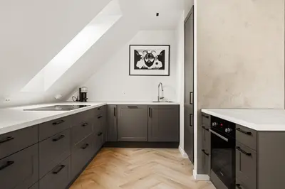 a kitchen with gray cabinets and a white counter top at Bergen City Living in Bergen