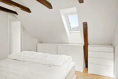 a white bedroom with a bed and a window at Bergen City Living in Bergen