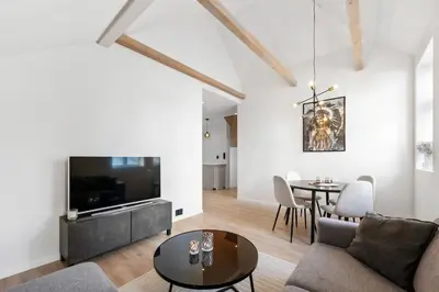a living room with a couch and a tv and a table at Newly renovated apartment in the heart of Bergen city center in Bergen