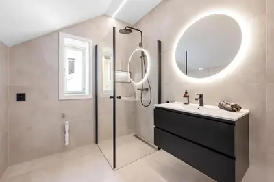 a bathroom with a shower and a sink and a mirror at Newly renovated apartment in the heart of Bergen city center in Bergen