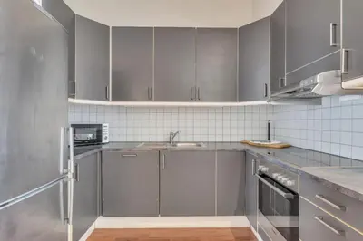a kitchen with stainless steel appliances and gray cabinets at Heimby - Seaside View Luxury - Free Parking in Bergen