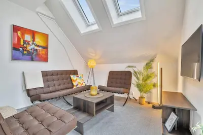 a living room with two couches and a tv at Heimby - Seaside Luxury - Free Parking in Bergen