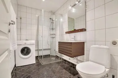 a bathroom with a toilet and a washing machine at Heimby - Seaside Luxury - Free Parking in Bergen