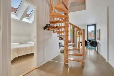 a wooden staircase in a bedroom with a bed at Heimby - Seaside Luxury - Free Parking in Bergen