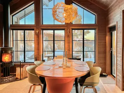 a dining room with a table and chairs and a chandelier at Modern Family Cabin By Tempelseter Ski Trails in Eggedal