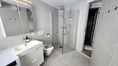 a bathroom with a shower and a toilet and a sink at Morgensolen in Bergen