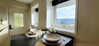 a kitchen with a table with glasses and a window at Morgensolen in Bergen