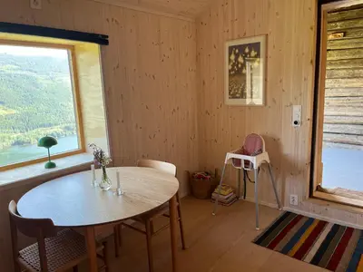 a dining room with a table and a window at Architect designed sleeping box in barn in Nos