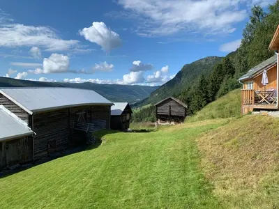 a house on a hill with a green field at Architect designed sleeping box in barn in Nos