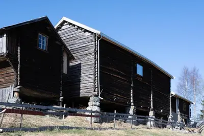 an old wooden barn sitting on top of a field at Architect designed sleeping box in barn in Nos