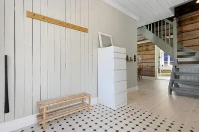 a room with a staircase and a table and a bench at Tømmerhuset på Brekketunet in Stryn