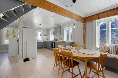 a kitchen and dining room with a table and chairs at Tømmerhuset på Brekketunet in Stryn