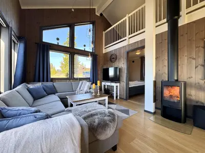 a living room with a couch and a fireplace at Modern mountain cabin in Tisleidalen, Golsfjellet in Gol