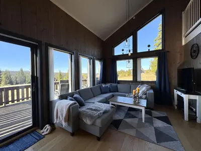 a living room with a couch and a table at Modern mountain cabin in Tisleidalen, Golsfjellet in Gol