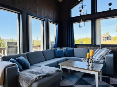 a living room with a blue couch and a table at Modern mountain cabin in Tisleidalen, Golsfjellet in Gol