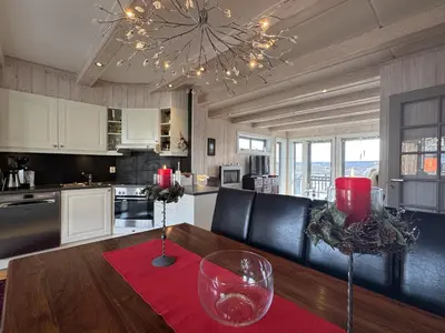 a kitchen with a table with two wine glasses on it at Ski-in ski-out at Kikut, Geilo, apartment with sauna in Geilo