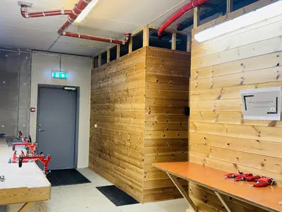 a wooden wall in a room with a table at Ski-in ski-out at Kikut, Geilo, apartment with sauna in Geilo