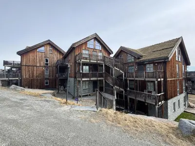 a group of wooden buildings on top of a hill at Ski-in ski-out at Kikut, Geilo, apartment with sauna in Geilo
