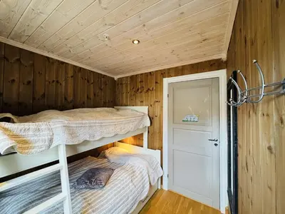 two bunk beds in a room with wooden walls at Ski-in ski-out at Kikut, Geilo, apartment with sauna in Geilo