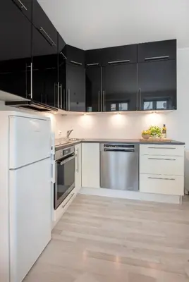a kitchen with white appliances and black cabinets at Apartment in the Heart of Ålesund in Ålesund