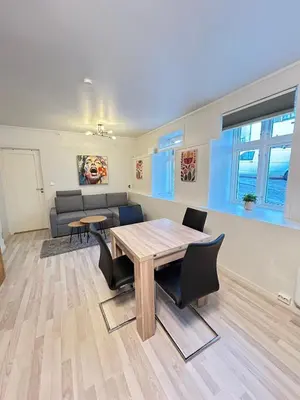 a living room with a wooden table and chairs at Apartment in the Heart of Ålesund in Ålesund