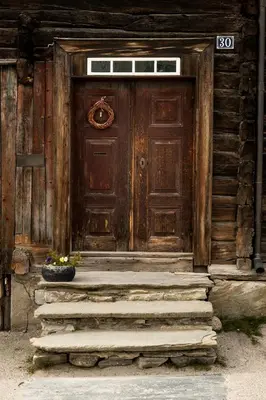 a wooden door with steps in front of a house at Per Amundsagården in Røros