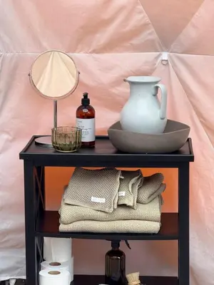 a table with a lamp and a vase on it at Idyllisk overnatting i dome ved sandstrand in Langenes