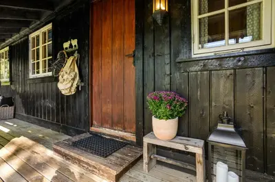 a porch of a house with a pot of flowers on a bench at Mountain Cabin With Cross-Country Trails In Rauland in Rauland