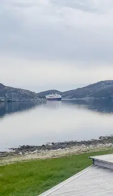 a boat in a large body of water at Coastal Cabin With Panoramic Views In Høvikstranda