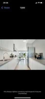 a kitchen with white cabinets and a refrigerator at Rom i nyere rekkehus nord i Haugesund in Haugesund