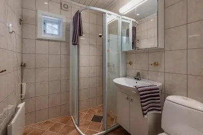 a bathroom with a shower and a toilet and a sink at A comfy House in Hol