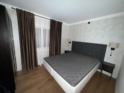 a bedroom with a bed and two windows at A comfy House in Hol