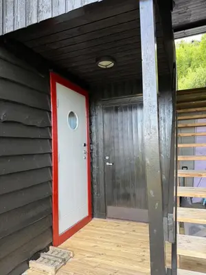 a red and white door in the side of a house at Apartment with a view at Bavallen Tråstølen Voss in Vossevangen