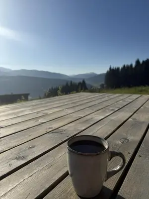 a cup of coffee sitting on a wooden table at Apartment with a view at Bavallen Tråstølen Voss in Vossevangen
