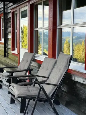 two chairs sitting on a porch with windows at Apartment with a view at Bavallen Tråstølen Voss in Vossevangen